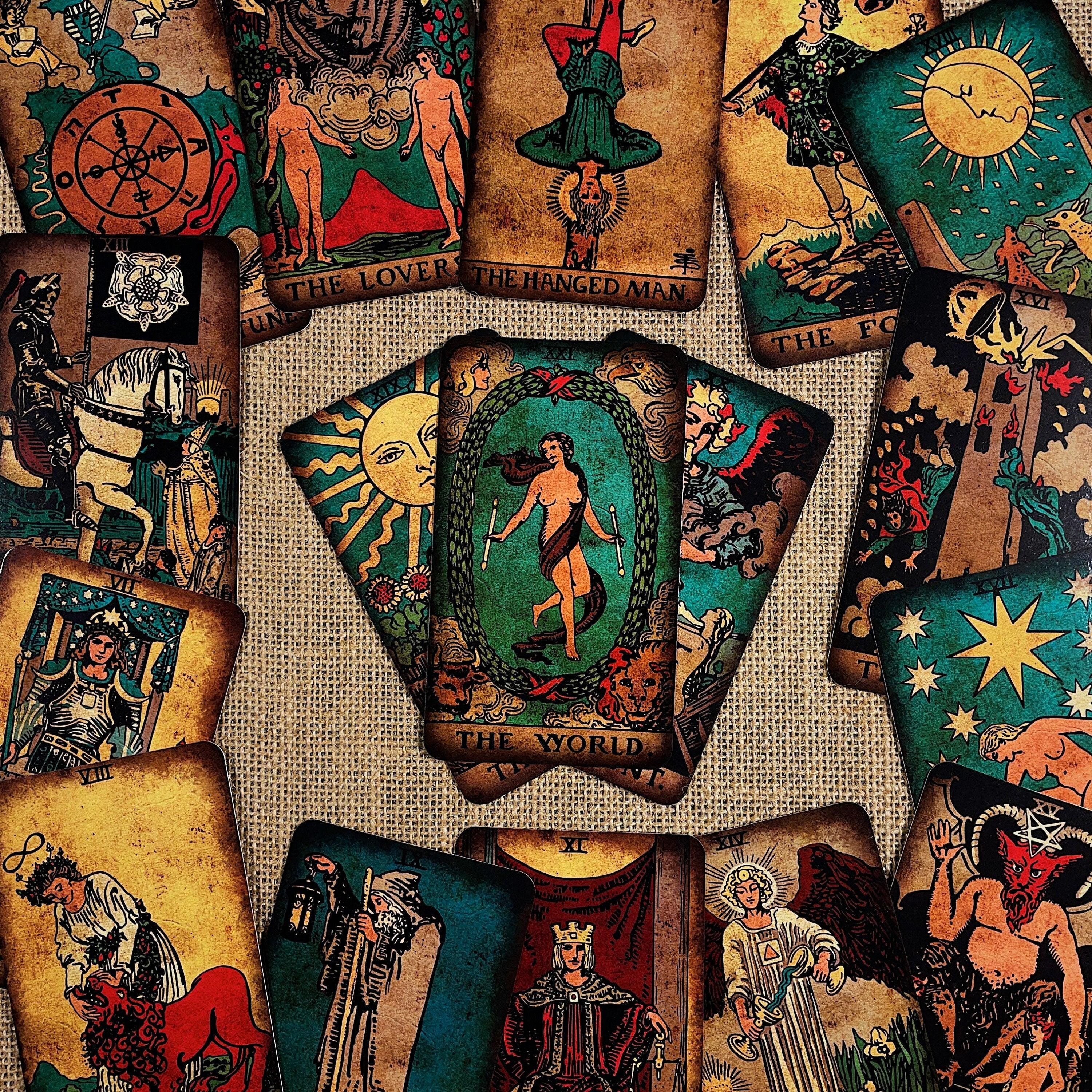 May include: A collection of vintage-style tarot cards with various illustrations and titles. The cards feature images of figures, symbols, and celestial bodies in a palette of earthy tones, greens, and blues. The central card reads "THE WORLD."